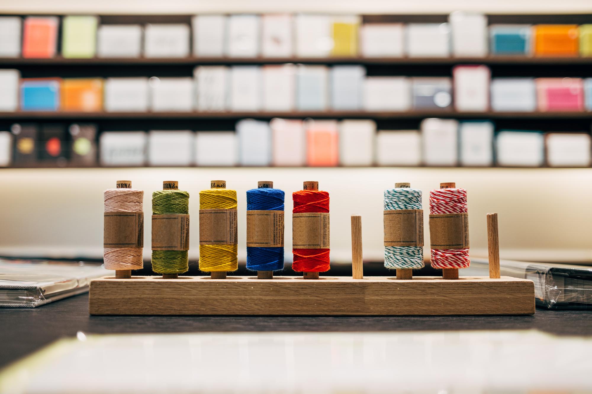 Wnętrze pracowni hafciarskiej z maszyną i niciami